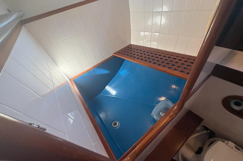 Tenacious Yacht Photos Pics 1987 Mikelson 50 yacht shower area with blue floor and white tiled walls.