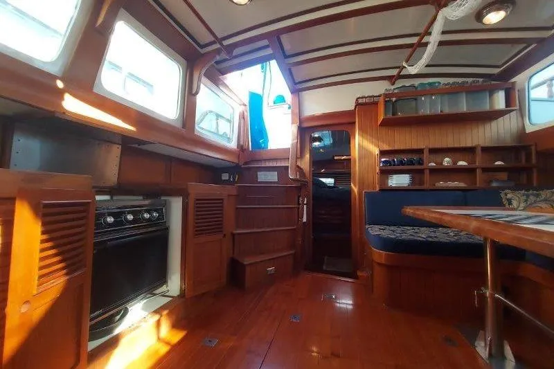 Tenacious Yacht Photos Pics Interior of 1987 Mikelson 50 yacht with wooden furnishings and cozy seating area.