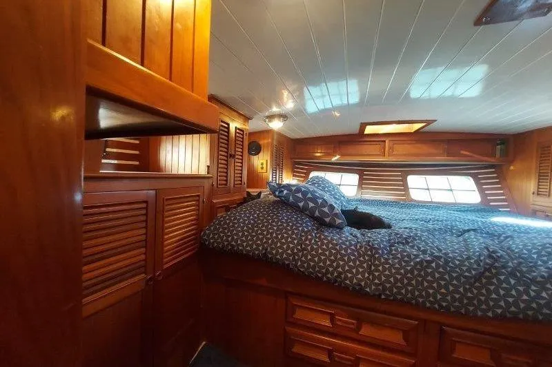 Tenacious Yacht Photos Pics Cozy cabin interior of 1987 Mikelson 50 yacht with wooden furnishings and bed.