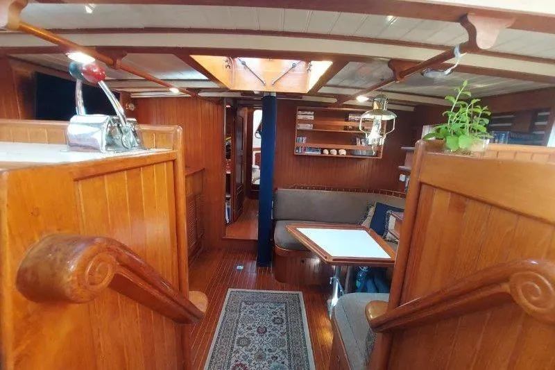 Tenacious Yacht Photos Pics Interior of 1987 Mikelson 50 yacht with wooden decor and cozy seating area.