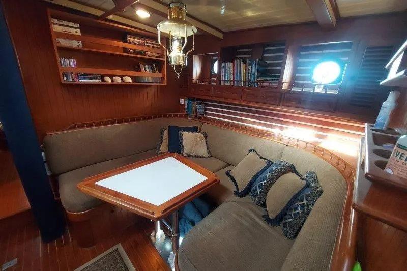 Tenacious Yacht Photos Pics Cozy interior of a 1987 Mikelson 50 yacht with plush seating and wooden accents.