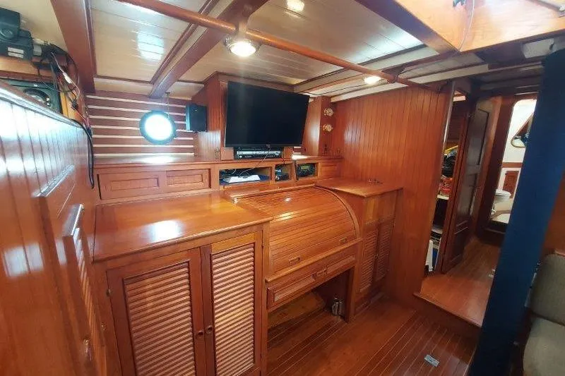 Tenacious Yacht Photos Pics Interior of 1987 Mikelson 50 yacht with wooden cabinetry and modern entertainment system.