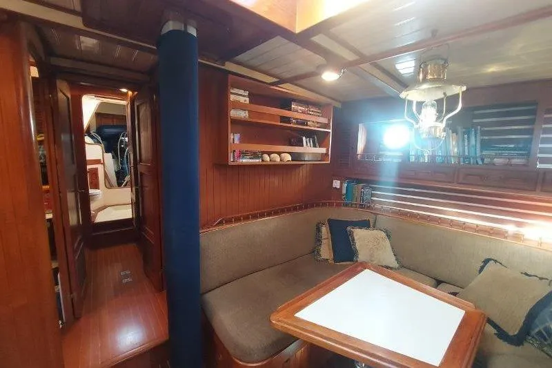 Tenacious Yacht Photos Pics Cozy interior of a 1987 Mikelson 50 yacht with wood paneling and seating area.