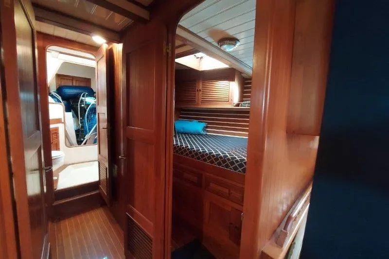 Tenacious Yacht Photos Pics Interior of 1987 Mikelson 50 yacht with wooden furnishings and cozy sleeping area.