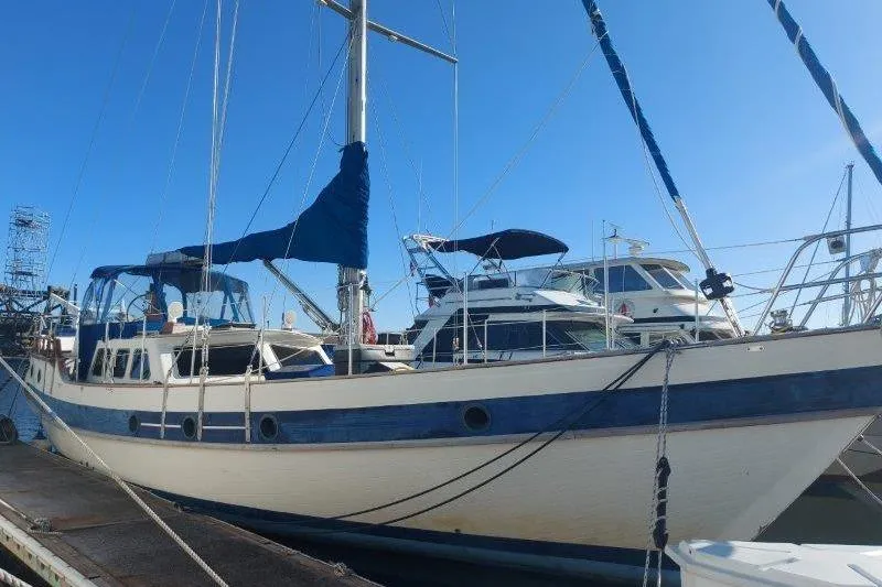 Tenacious Yacht Photos Pics 1987 Mikelson 50 sailboat docked at marina under clear blue sky.