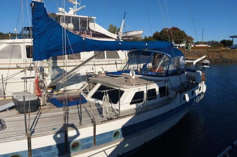 Tenacious Yacht Photos Pics 1987 Mikelson 50 sailboat docked, featuring blue sails and a spacious deck.