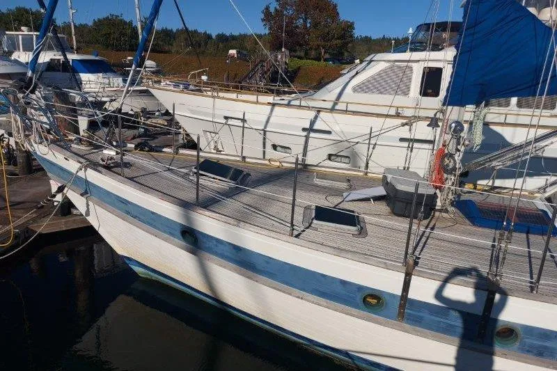 Tenacious Yacht Photos Pics 1987 Mikelson 50 yacht docked at marina, featuring blue and white design.