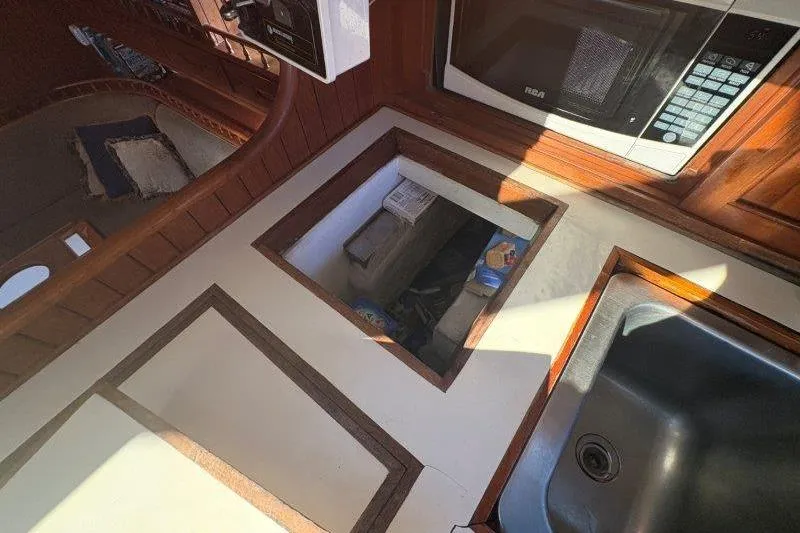 Tenacious Yacht Photos Pics 1987 Mikelson 50 yacht interior with kitchen sink, microwave, and storage compartment.