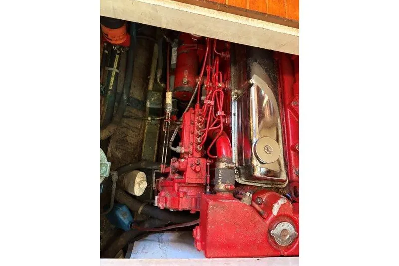 Tenacious Yacht Photos Pics Engine compartment of a 1987 Mikelson 50 boat, featuring red mechanical components.