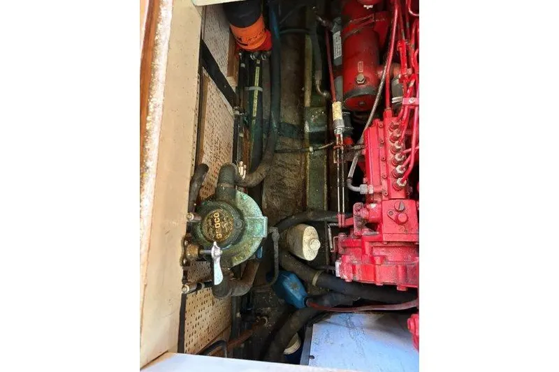 Tenacious Yacht Photos Pics Engine compartment of a 1987 Mikelson 50 boat, showcasing mechanical components and hoses.