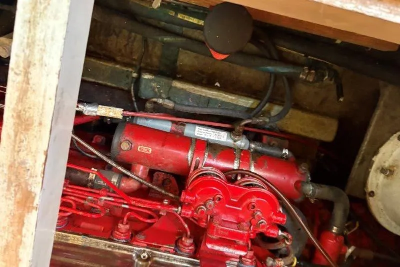 Tenacious Yacht Photos Pics Engine compartment of a 1987 Mikelson 50 boat, featuring red mechanical components.