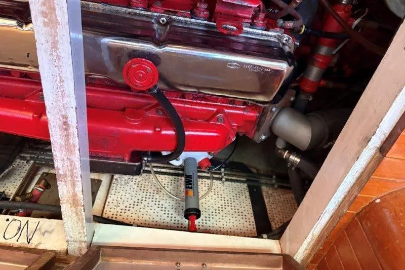 Tenacious Yacht Photos Pics Engine compartment of a 1987 Mikelson 50 boat, featuring a red engine and metallic components.