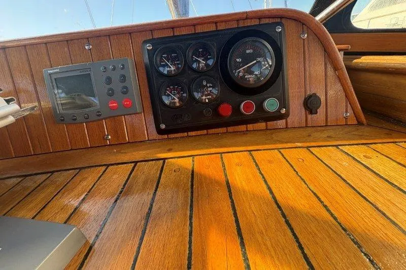 Tenacious Yacht Photos Pics 1987 Mikelson 50 yacht dashboard with wooden paneling and instrument gauges.