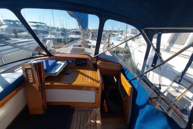 Tenacious Yacht Photos Pics 1987 Mikelson 50 yacht cockpit with wooden interior and marina view.
