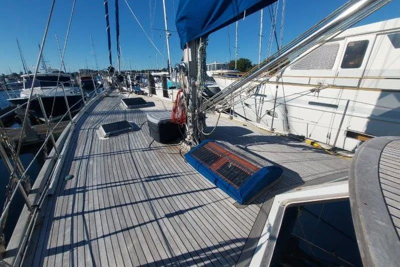 Tenacious Yacht Photos Pics 1987 Mikelson 50 yacht deck with blue canopy, docked in a marina under clear skies.