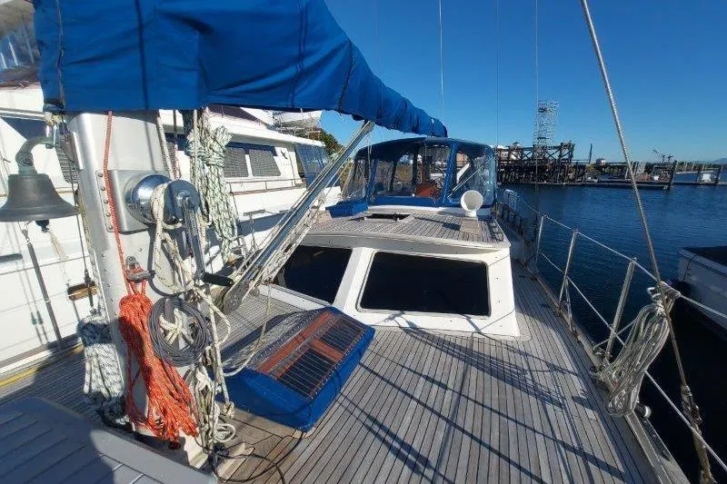 Tenacious Yacht Photos Pics 1987 Mikelson 50 yacht with blue canopy docked at marina, clear sky background.