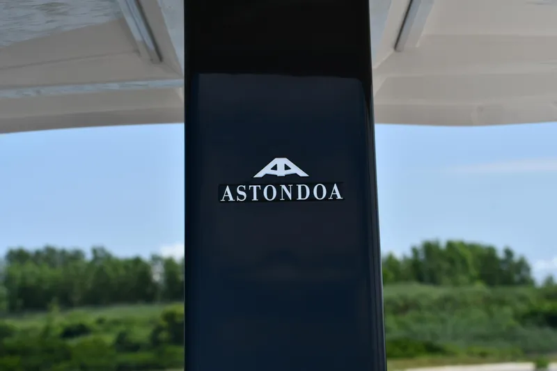  Yacht Photos Pics Astondoa 377 Coupe Outboard 2023 logo on sleek black surface, outdoor background.