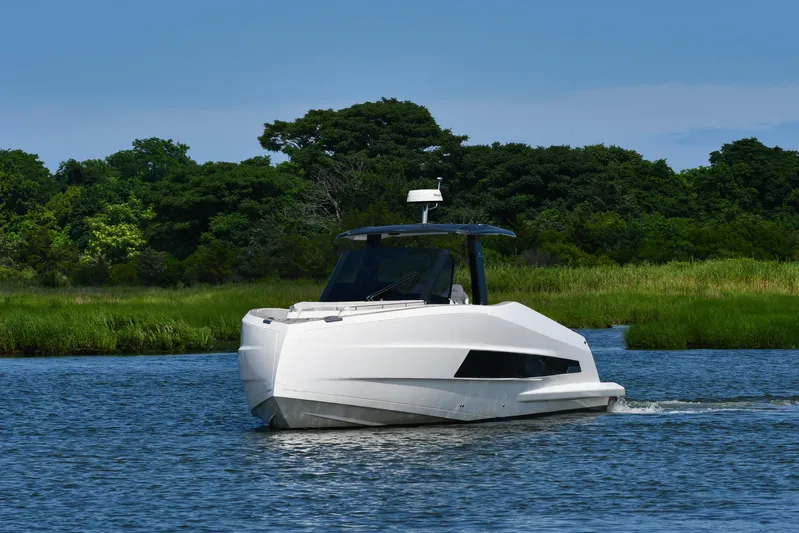  Yacht Photos Pics 2023 Astondoa 377 Coupe Outboard cruising on a serene river with lush greenery.