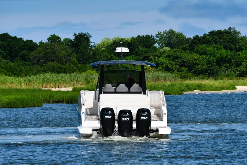  Yacht Photos Pics 2023 Astondoa 377 Coupe Outboard cruising on a scenic waterway with lush greenery.