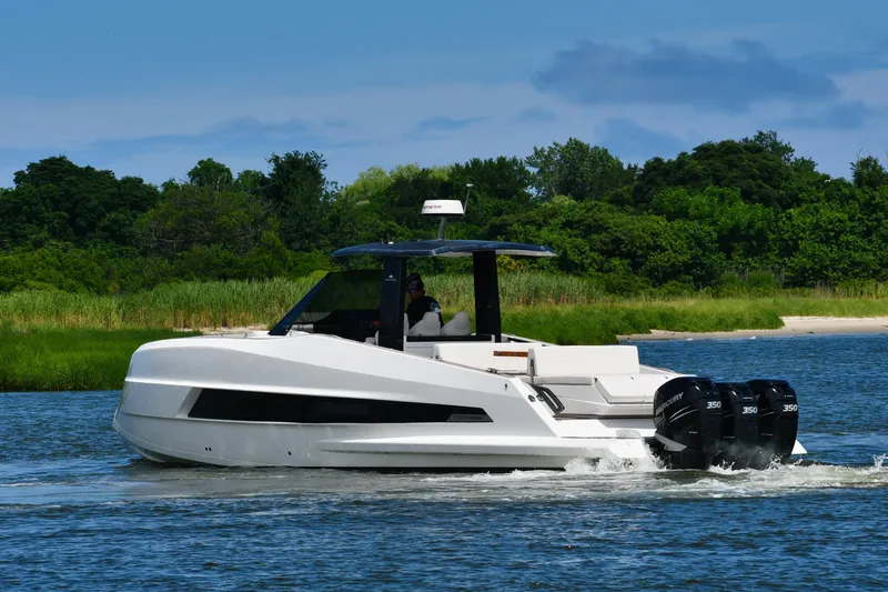  Yacht Photos Pics 2023 Astondoa 377 Coupe Outboard cruising on a scenic waterway with lush greenery.