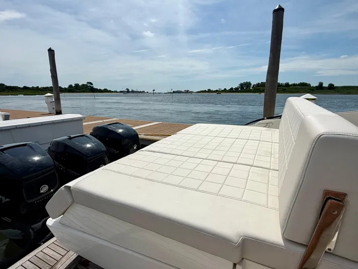  Yacht Photos Pics 2023 Astondoa 377 Coupe Outboard with white seating, docked by a serene waterfront.