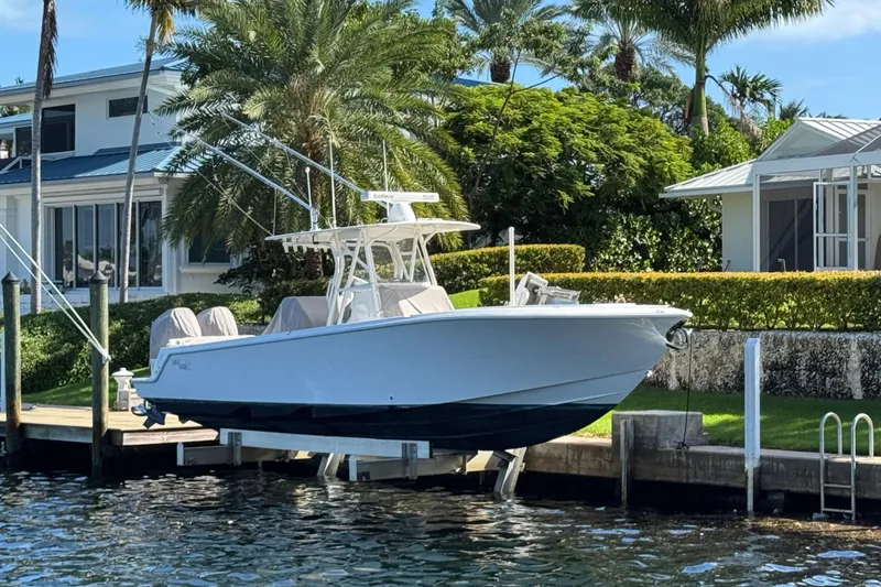  Yacht Photos Pics 2023 SeaVee 340Z boat docked by waterfront home with lush greenery.