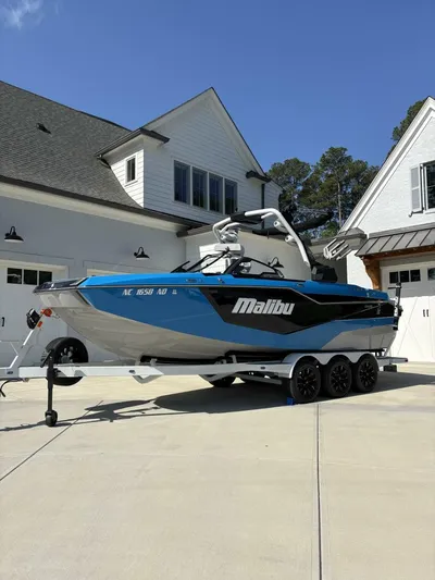  Yacht Photos Pics 2024 Malibu M242 boat on trailer in driveway, blue and white design.