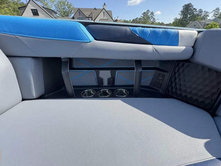  Yacht Photos Pics 2024 Malibu M242 boat interior with blue and gray seating, cup holders, and modern design.