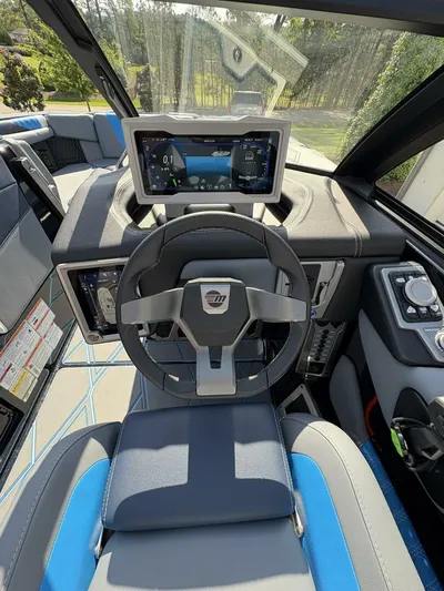  Yacht Photos Pics 2024 Malibu M242 boat cockpit with modern steering wheel and digital display.