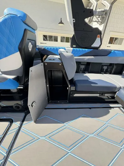  Yacht Photos Pics 2024 Malibu M242 boat interior with blue seating and storage compartment.