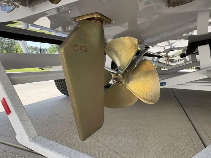  Yacht Photos Pics 2024 Malibu M242 boat propeller and rudder on a trailer, showcasing marine engineering.