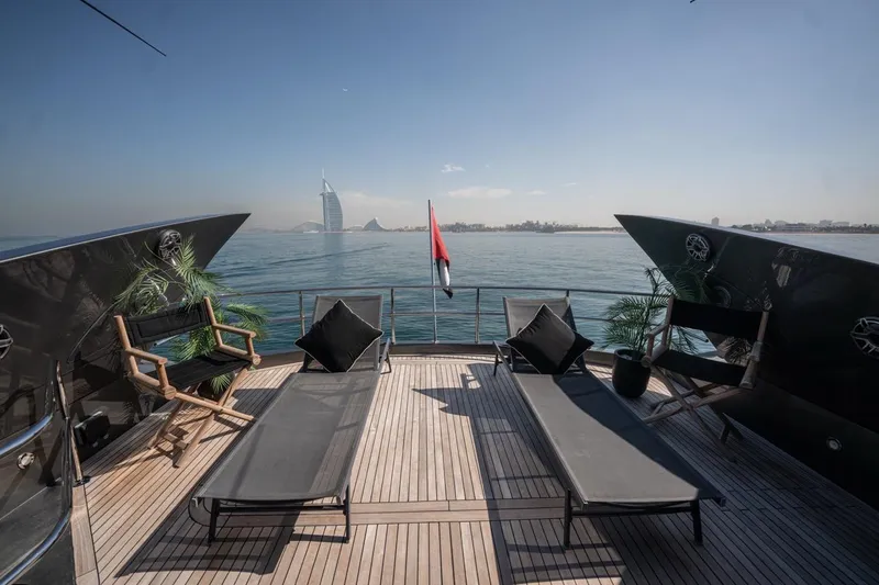 The Matrix Yacht Photos Pics Luxurious Sunseeker 82 Yacht deck with lounge chairs, ocean view, and iconic skyline backdrop.