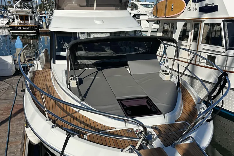 Vitamin Sea Yacht Photos Pics 2023 Beneteau Antares 11 Fly yacht with sunbathing area, docked at marina.