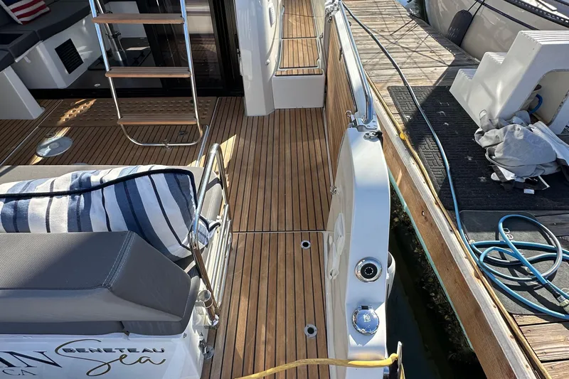 Vitamin Sea Yacht Photos Pics 2023 Beneteau Antares 11 Fly boat deck with wooden flooring and seating area.