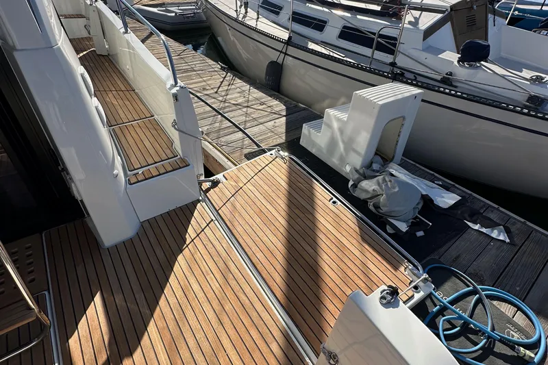 Vitamin Sea Yacht Photos Pics 2023 Beneteau Antares 11 Fly yacht with teak deck at marina dock.