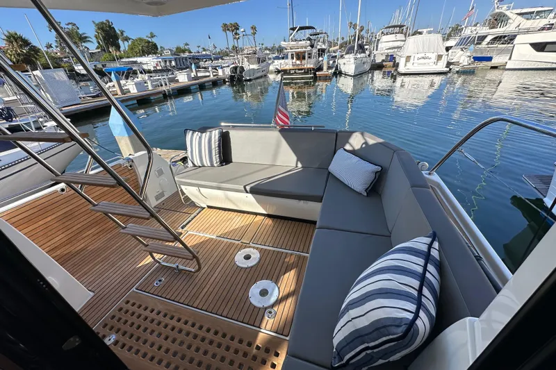 Vitamin Sea Yacht Photos Pics 2023 Beneteau Antares 11 Fly yacht with elegant seating at a marina.