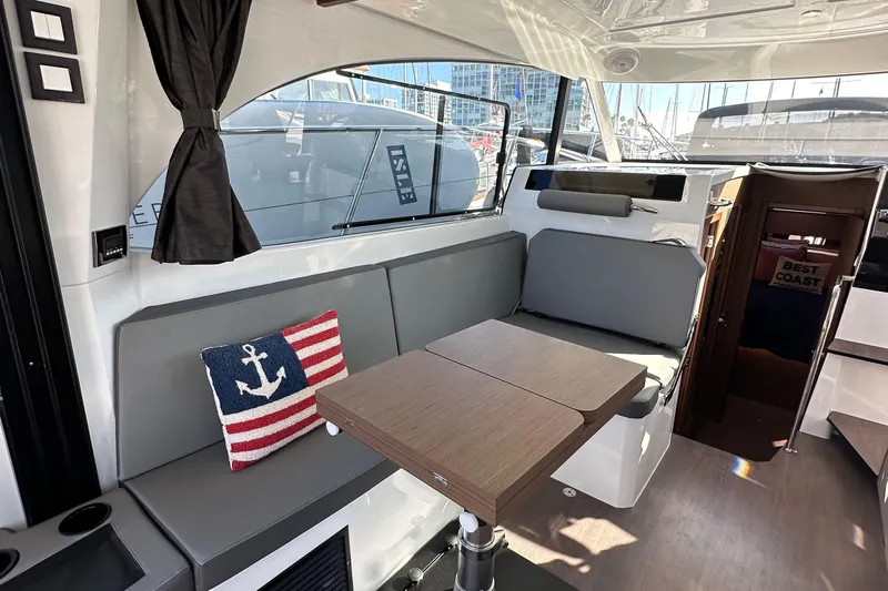Vitamin Sea Yacht Photos Pics Interior of 2023 Beneteau Antares 11 Fly with seating, table, and nautical decor.