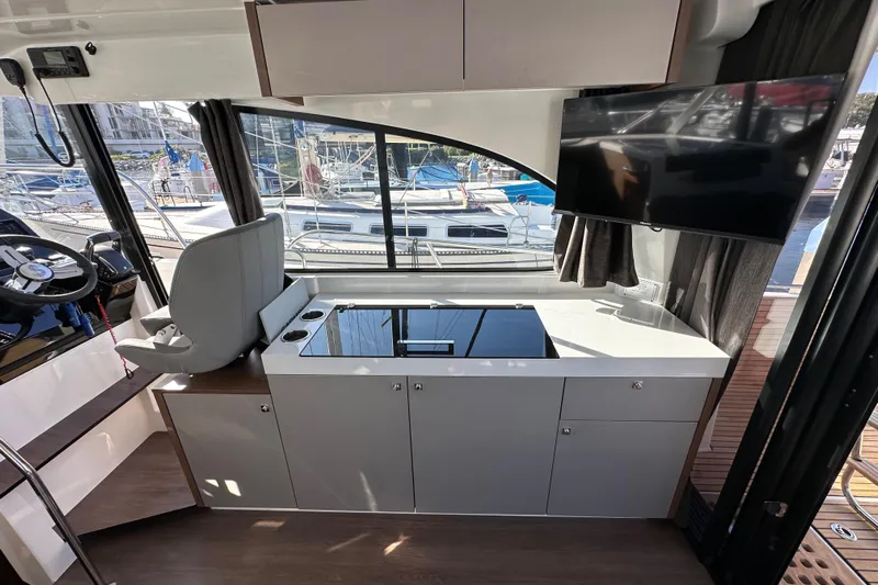 Vitamin Sea Yacht Photos Pics Interior of 2023 Beneteau Antares 11 Fly, featuring helm, kitchenette, and marina view.