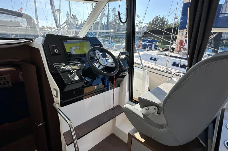 Vitamin Sea Yacht Photos Pics Interior helm of 2023 Beneteau Antares 11 Fly with navigation controls and steering wheel.