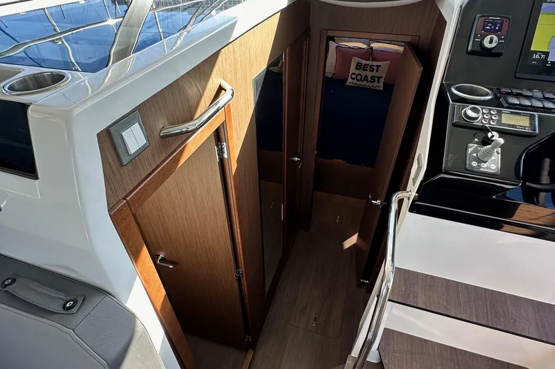 Vitamin Sea Yacht Photos Pics Interior view of 2023 Beneteau Antares 11 Fly, featuring wooden cabinetry and control panel.