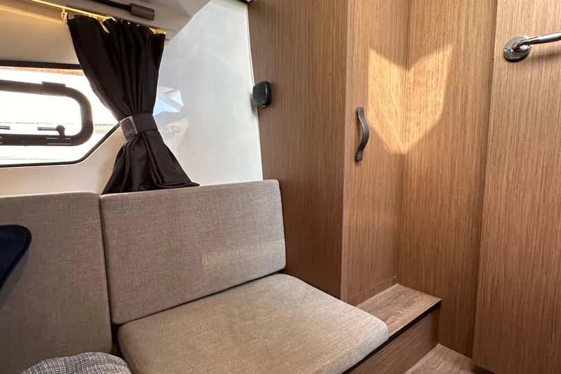 Vitamin Sea Yacht Photos Pics Interior of 2023 Beneteau Antares 11 Fly, featuring cozy seating and wooden cabinetry.