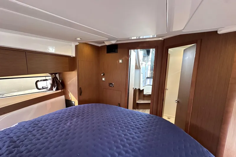 Vitamin Sea Yacht Photos Pics Interior cabin of 2023 Beneteau Antares 11 Fly with wood finish and blue bedding.