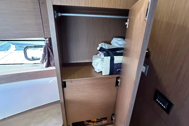 Vitamin Sea Yacht Photos Pics Interior storage of 2023 Beneteau Antares 11 Fly yacht with open wooden cabinet.