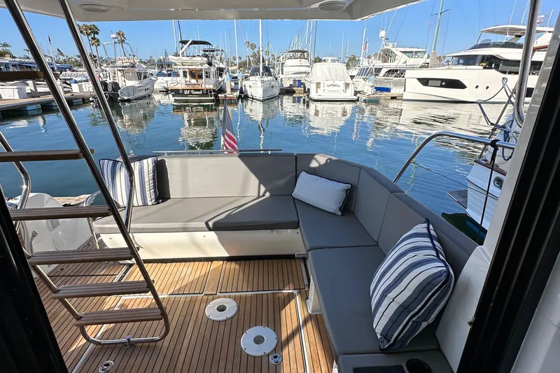 Vitamin Sea Yacht Photos Pics 2023 Beneteau Antares 11 Fly yacht interior with cushioned seating and marina view.