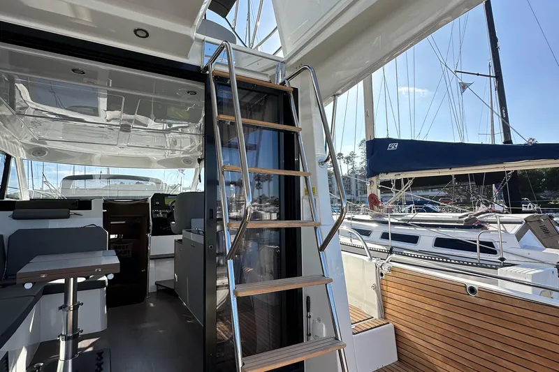 Vitamin Sea Yacht Photos Pics 2023 Beneteau Antares 11 Fly interior with wooden steps and marina view.