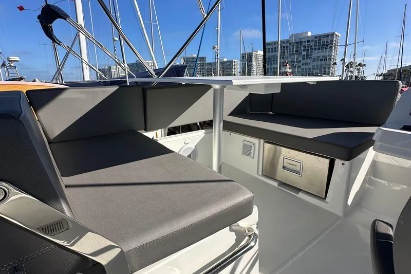Vitamin Sea Yacht Photos Pics 2023 Beneteau Antares 11 Fly boat seating area with modern design and marina backdrop.