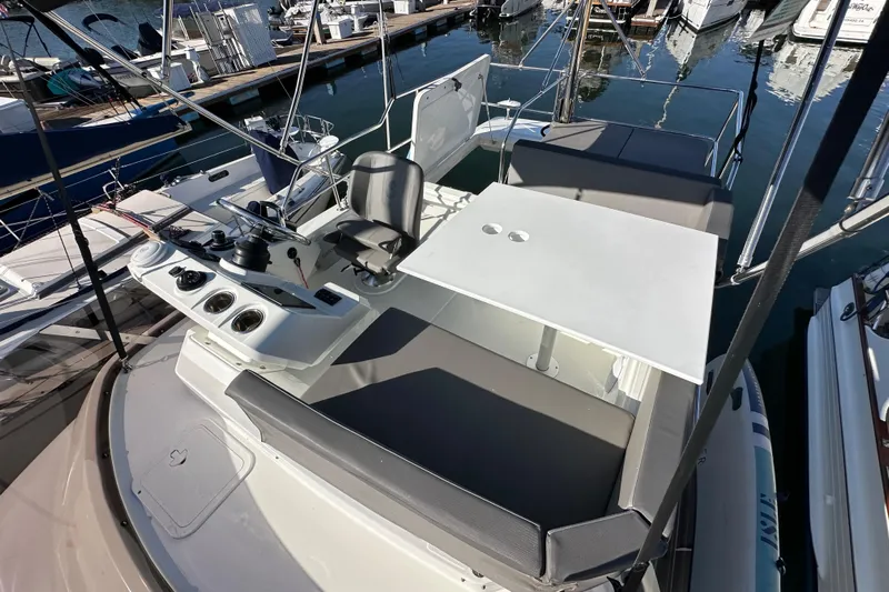 Vitamin Sea Yacht Photos Pics 2023 Beneteau Antares 11 Flybridge with seating and control panel at marina.