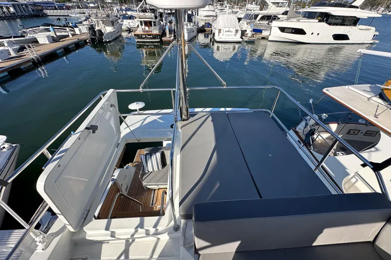 Vitamin Sea Yacht Photos Pics 2023 Beneteau Antares 11 Fly yacht at marina, showcasing flybridge and seating area.