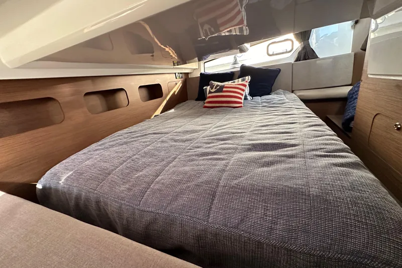 Vitamin Sea Yacht Photos Pics Cozy cabin interior of 2023 Beneteau Antares 11 Fly with stylish bedding and cushions.