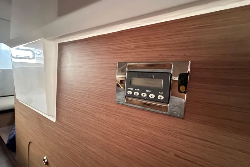 Vitamin Sea Yacht Photos Pics Control panel on 2023 Beneteau Antares 11 Fly's wooden interior wall.